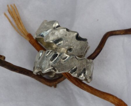 Ehering komplett aus 925er Silber. Die Kanten mit wellenartigem Verlauf sind glänzend poliert. Oberflaeche eismatt gekratzt. Die Breite des Ringes betraegt 9 mm.